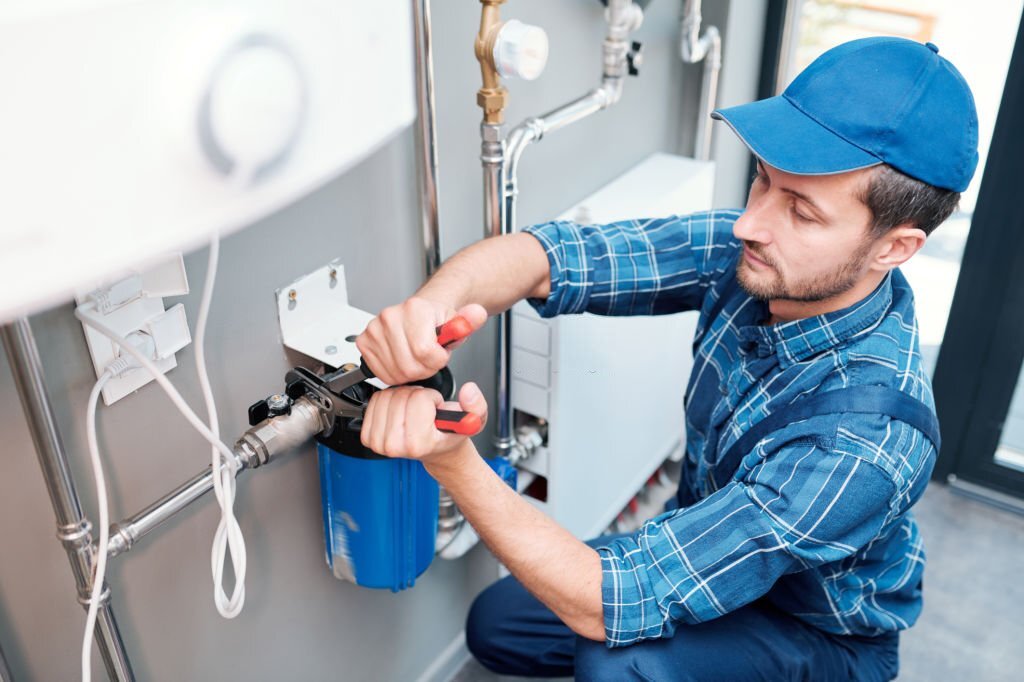 A plumber working on a water heater.
