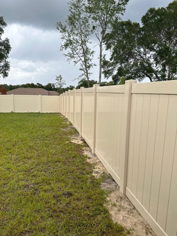 A white vinyl fencing in a backyard.