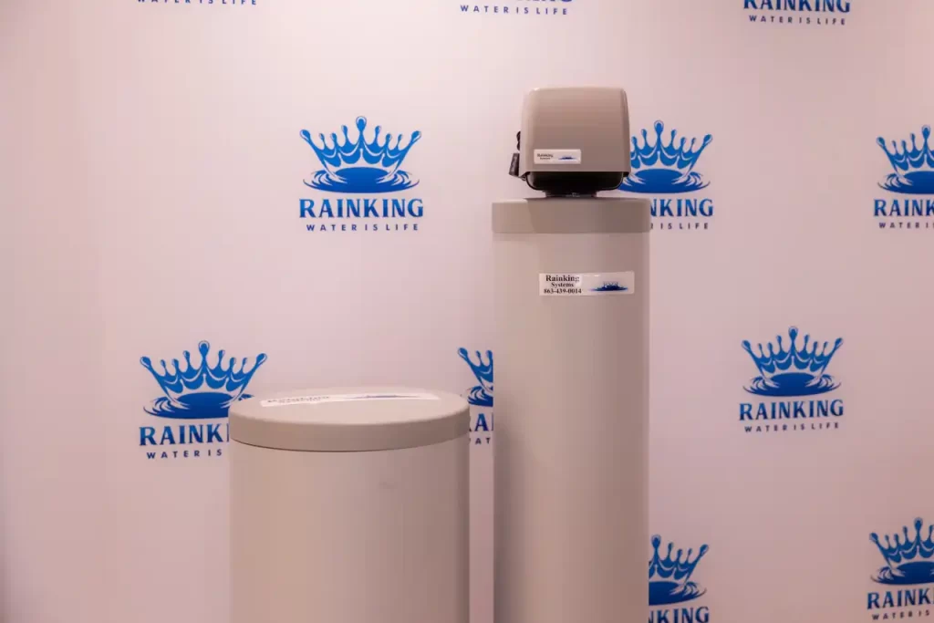 Two water softeners in front of a wall.