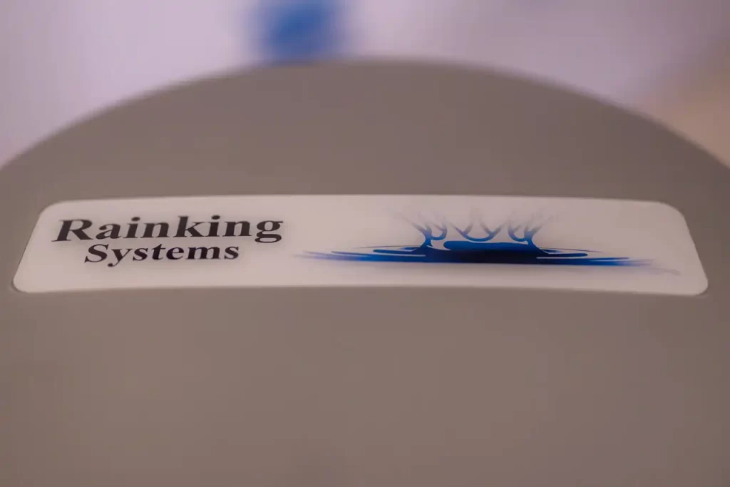 A sign on a surface reads "Rainking Systems" with a graphic of blue water splashes beside it.