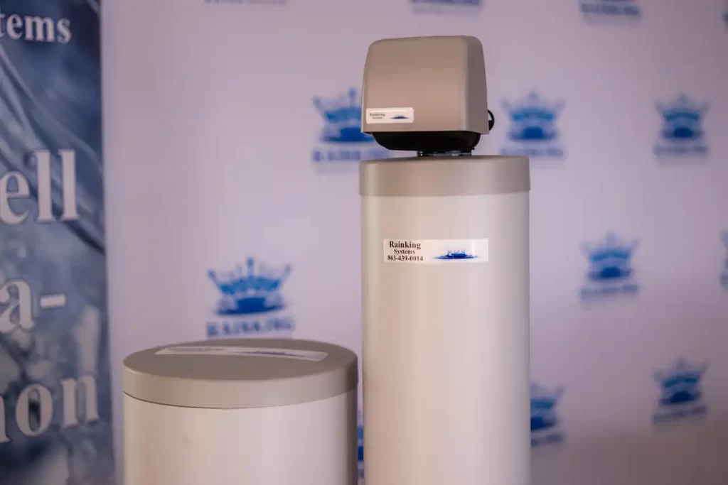 Two water softeners in front of a banner.